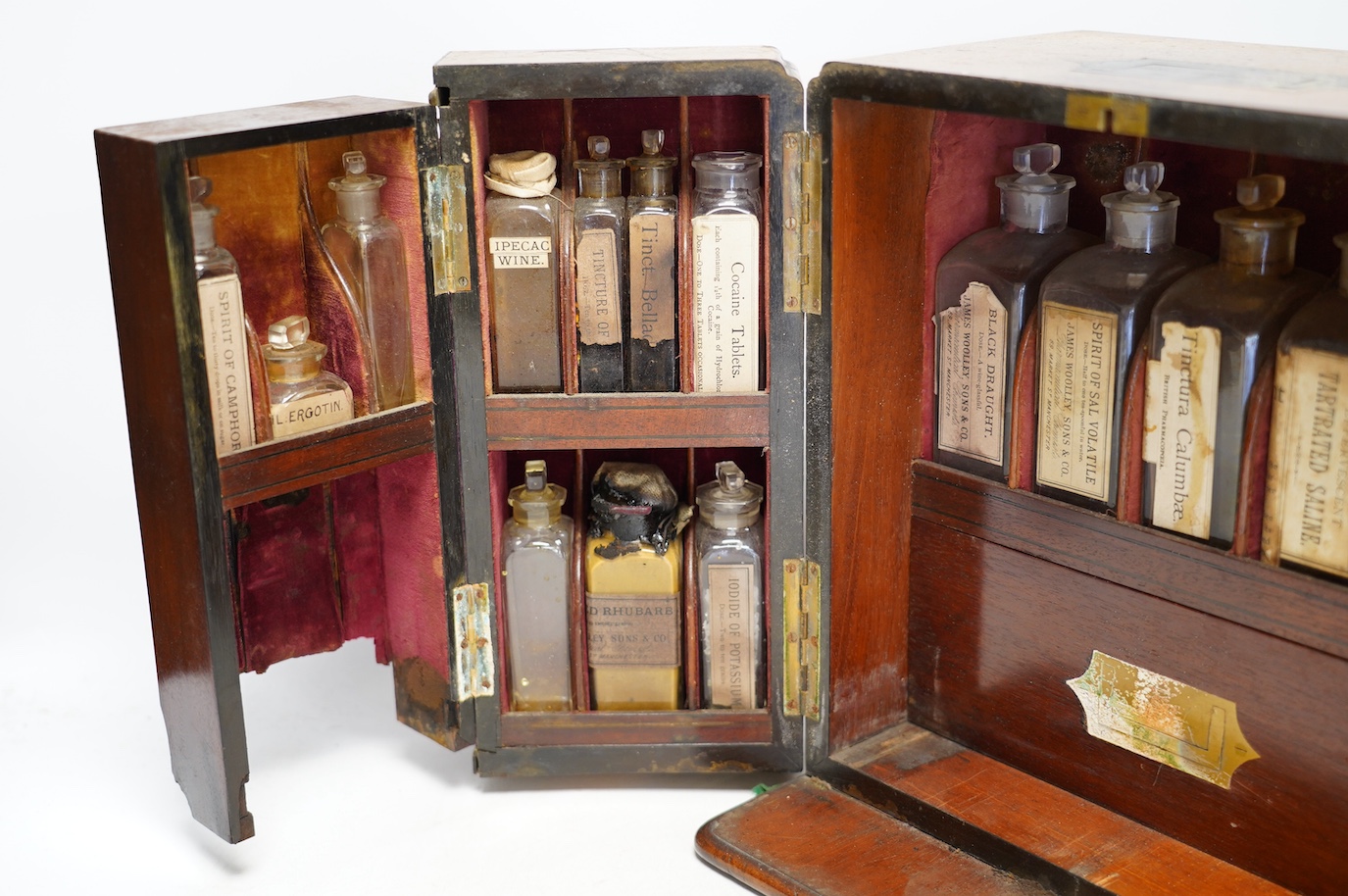 A late Victorian mahogany apothecary chest, containing a number of labelled glass bottles with preparations by James Woolley Sons and Co, Pharmaceutical Chemists, 28.5cm high, 25.5cm wide, 21cm deep. Condition - poor to